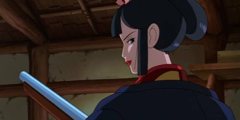 Lady Eboshi with one of her rifles turning around and smiling confidently in Princess Mononoke.