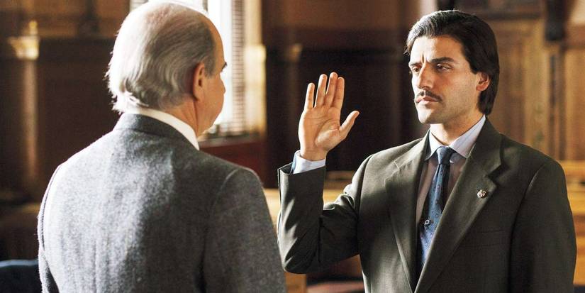 Oscar Isaac facing someone with one hand raised in a courtroom in HBO's Show Me A Hero.