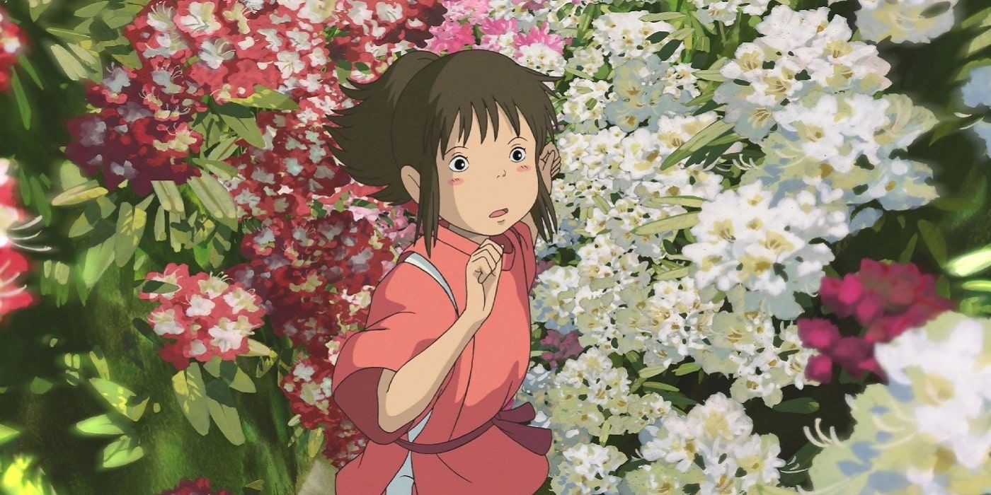 Chihiro standing among flowers and looking up in 'Spirited Away'.