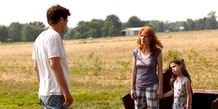 Jessica Chastain, Tova Stewart, and Shea Whigham standing in a field in Take Shelter 