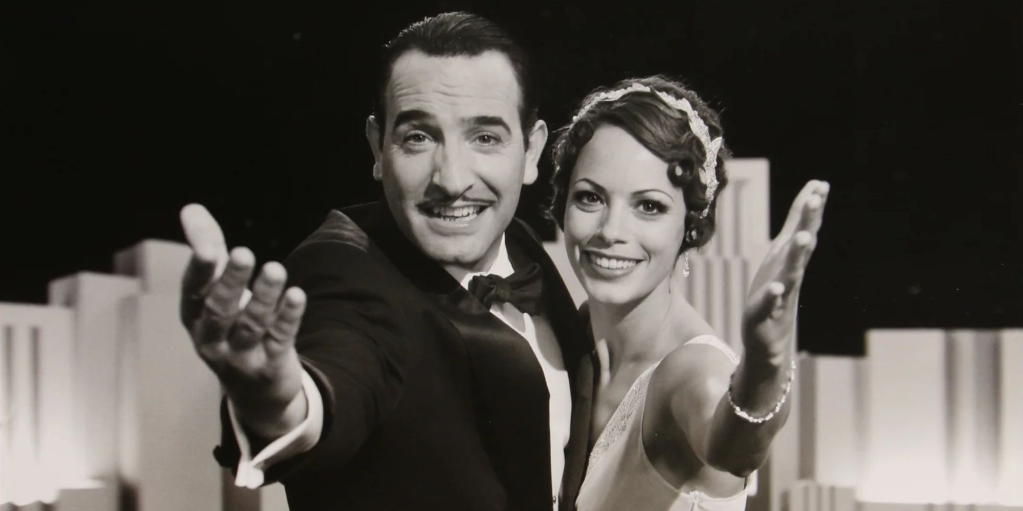 George and Peppy smiling and reaching out to the camera in The Artist - 2011 - poster.
