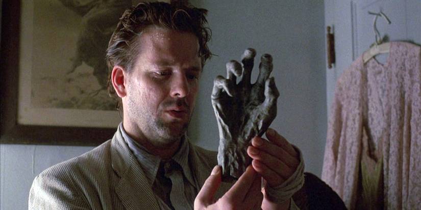 Harry Angel (Mickey Rourke) inspecting an occult object in Angel Heart