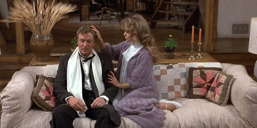 Michael Caine as Sidney and Dyan Cannon as Myra sitting together on the couch in Deathtrap (1982)