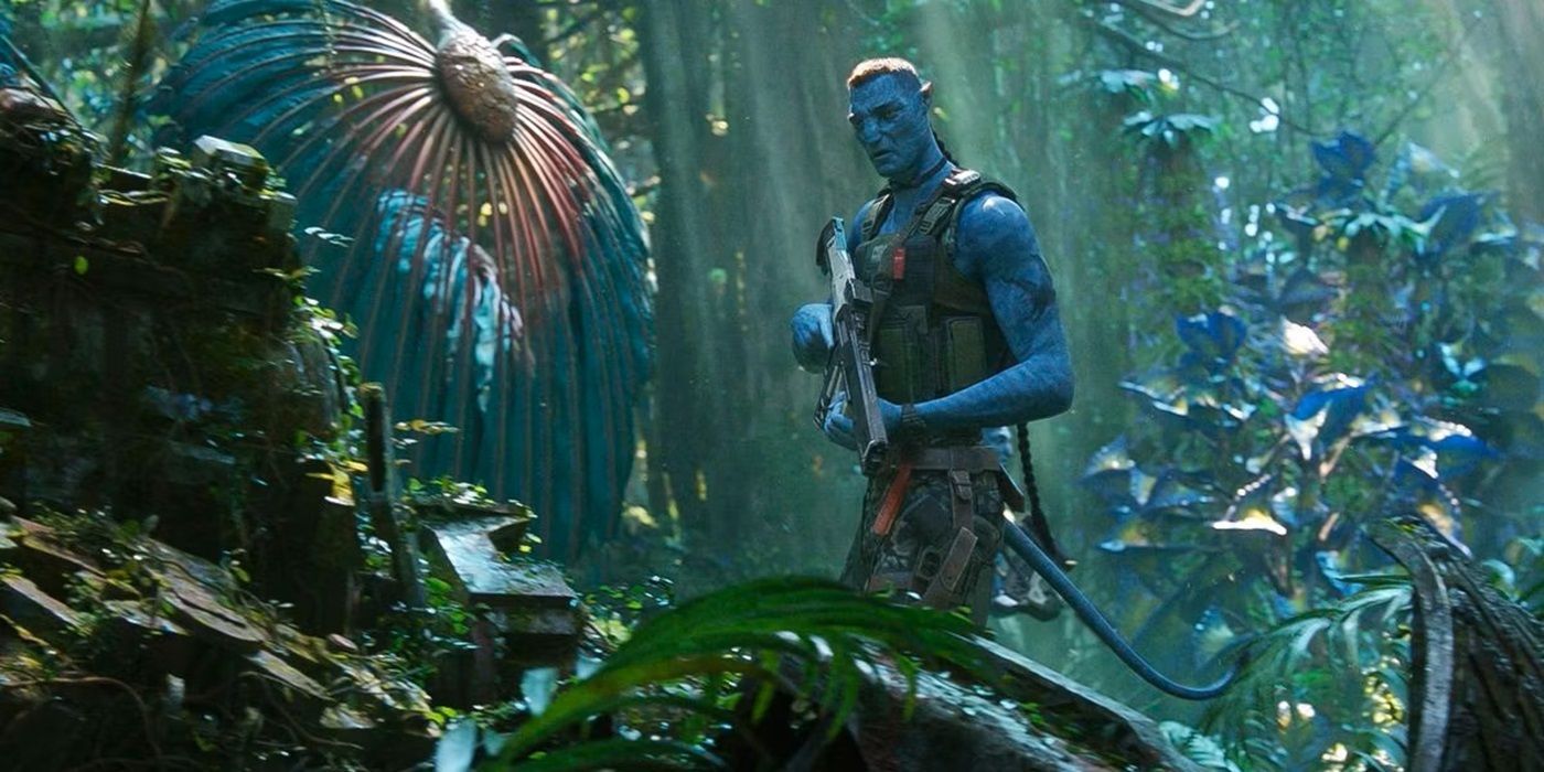 Stephen Lang as Colonel Quaritch in his Na'vi avatar standing in a forest in Avatar: The Way of Water