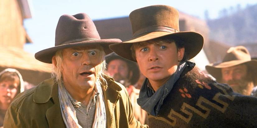 Marty McFly, played by Michael J. Fox, and Doc Brown, played by Christopher Lloyd, stand in cowboy attire in 'Back to the Future Part III.'