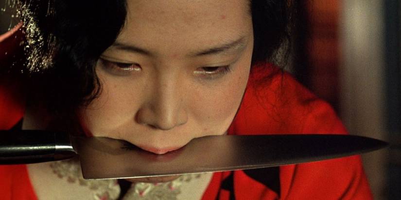 Sada with a knife between her teeth in In the Realm of the Senses
