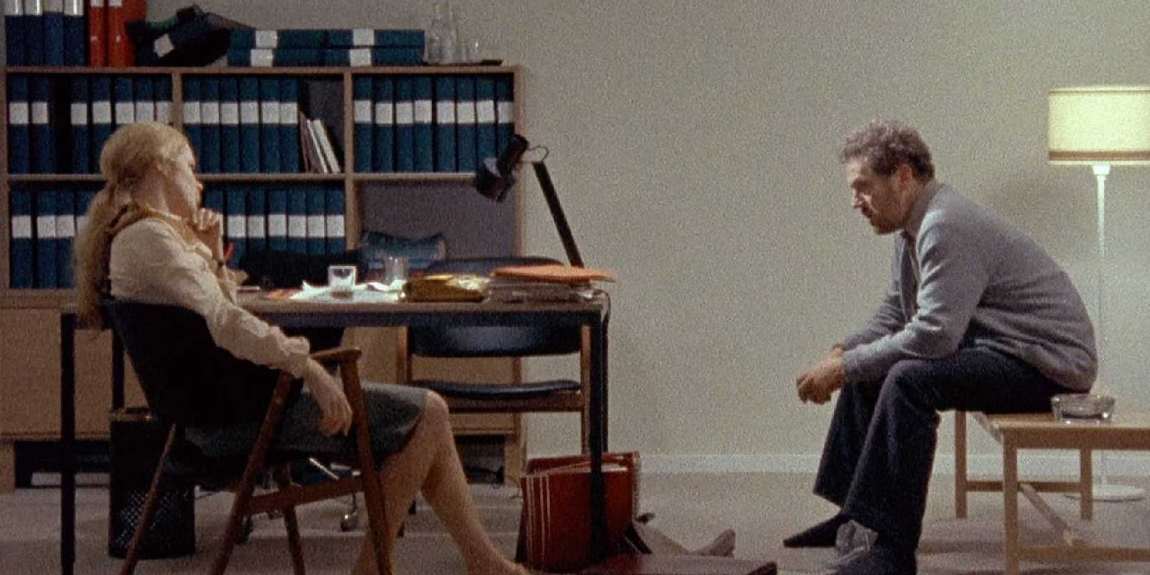 Erland Josephson and Liv Ullmann sitting in chairs facing each other in Scenes From a Marriage