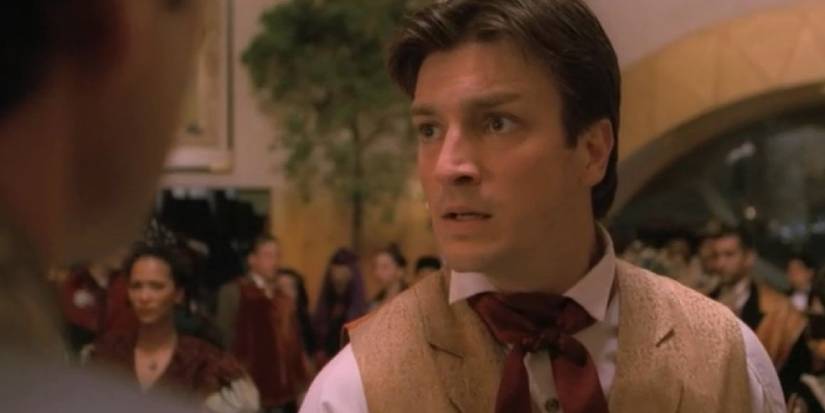 Malcolm Reynolds at a crowded event looks scared in a scene from Firefly.