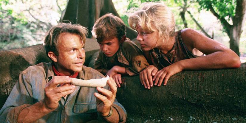 Actors Sam Neill, Joseph Mazello, and Ariana Richards as Alan Grant, Tim and Lex, gathered round observing an egg shell in Jurassic Park