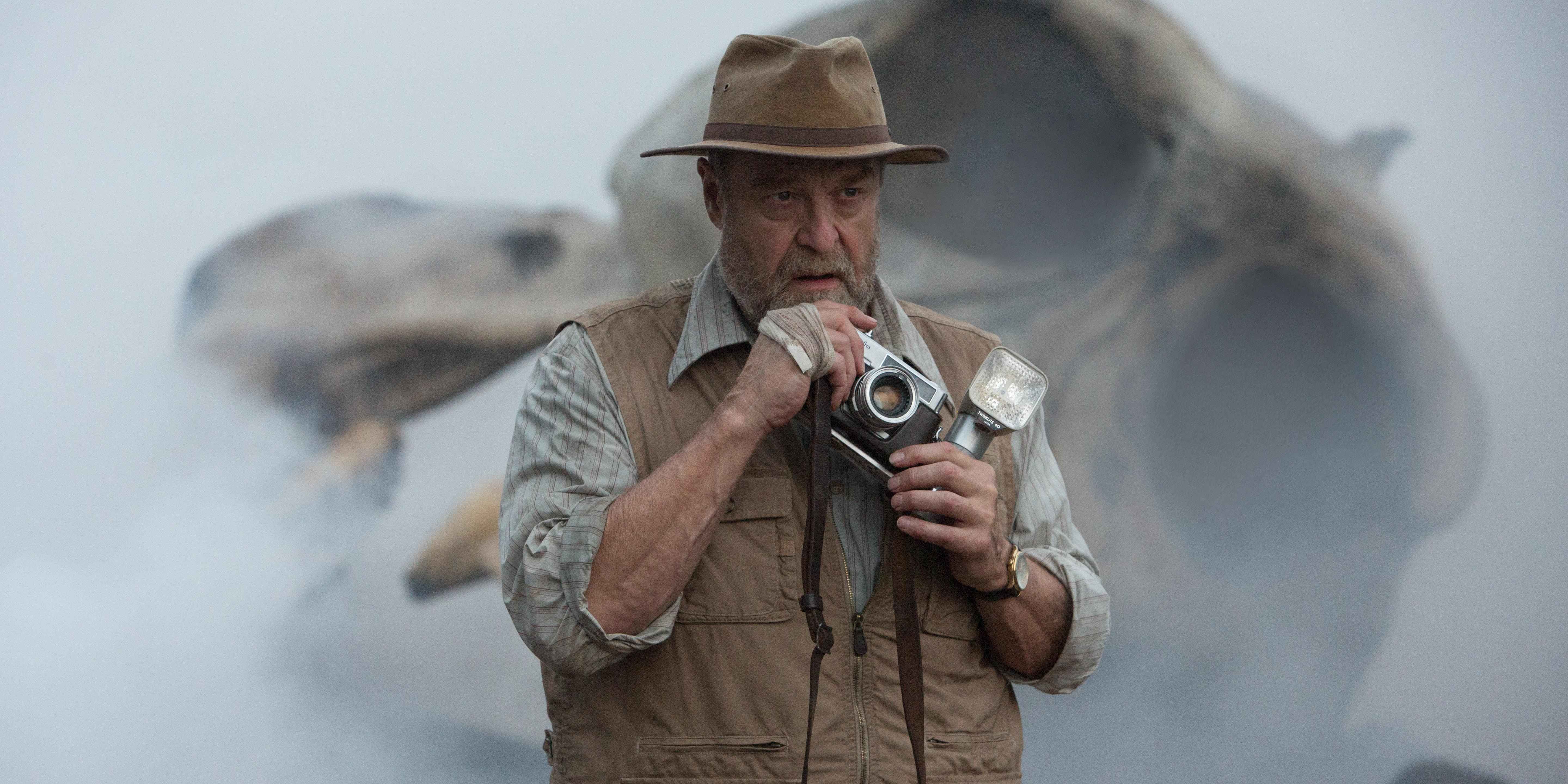Bill Randa stands with a giant skull behind him in Kong: Skull Island