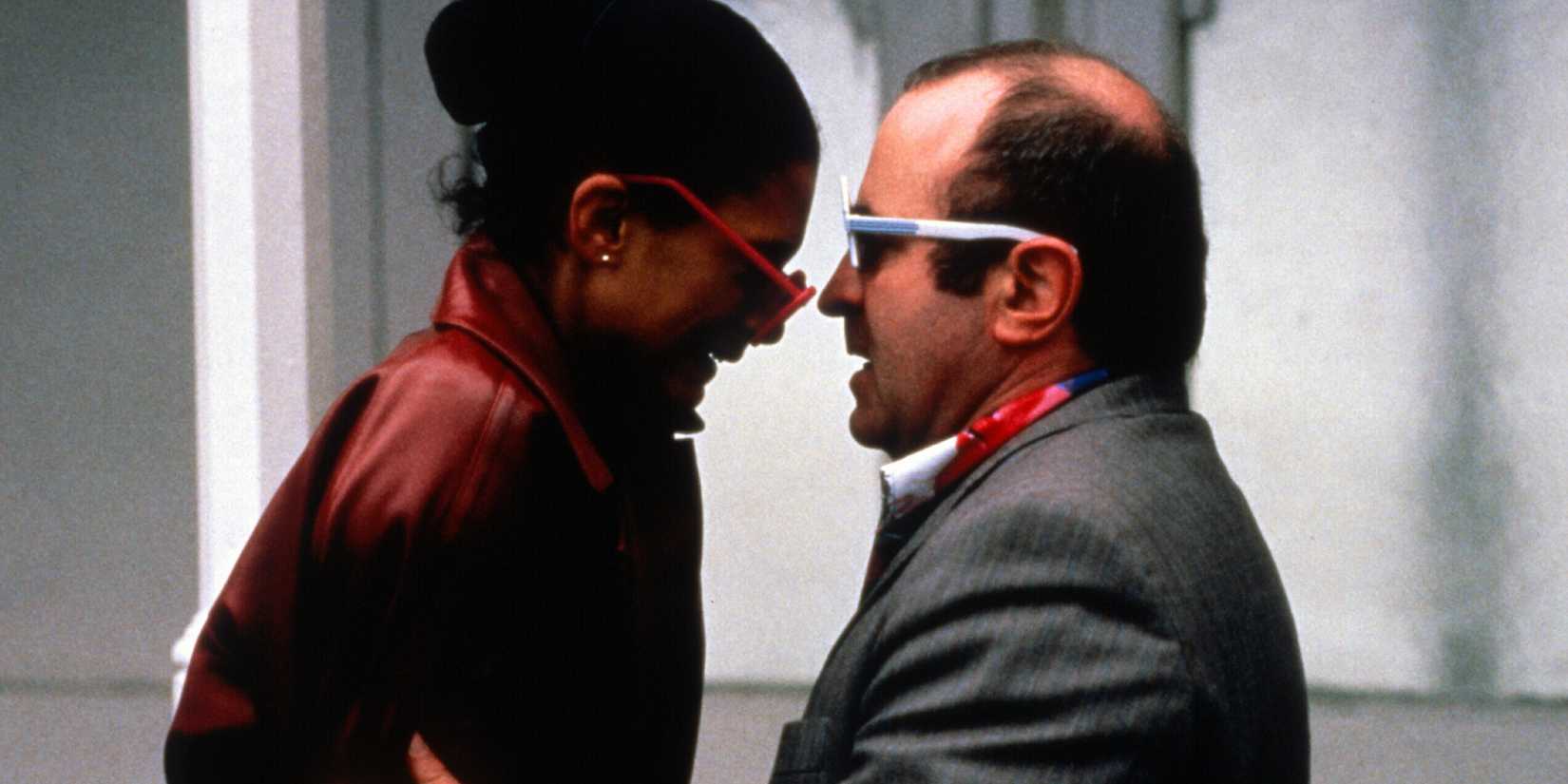 Simone and George facing each other on the street in the film Mona Lisa.