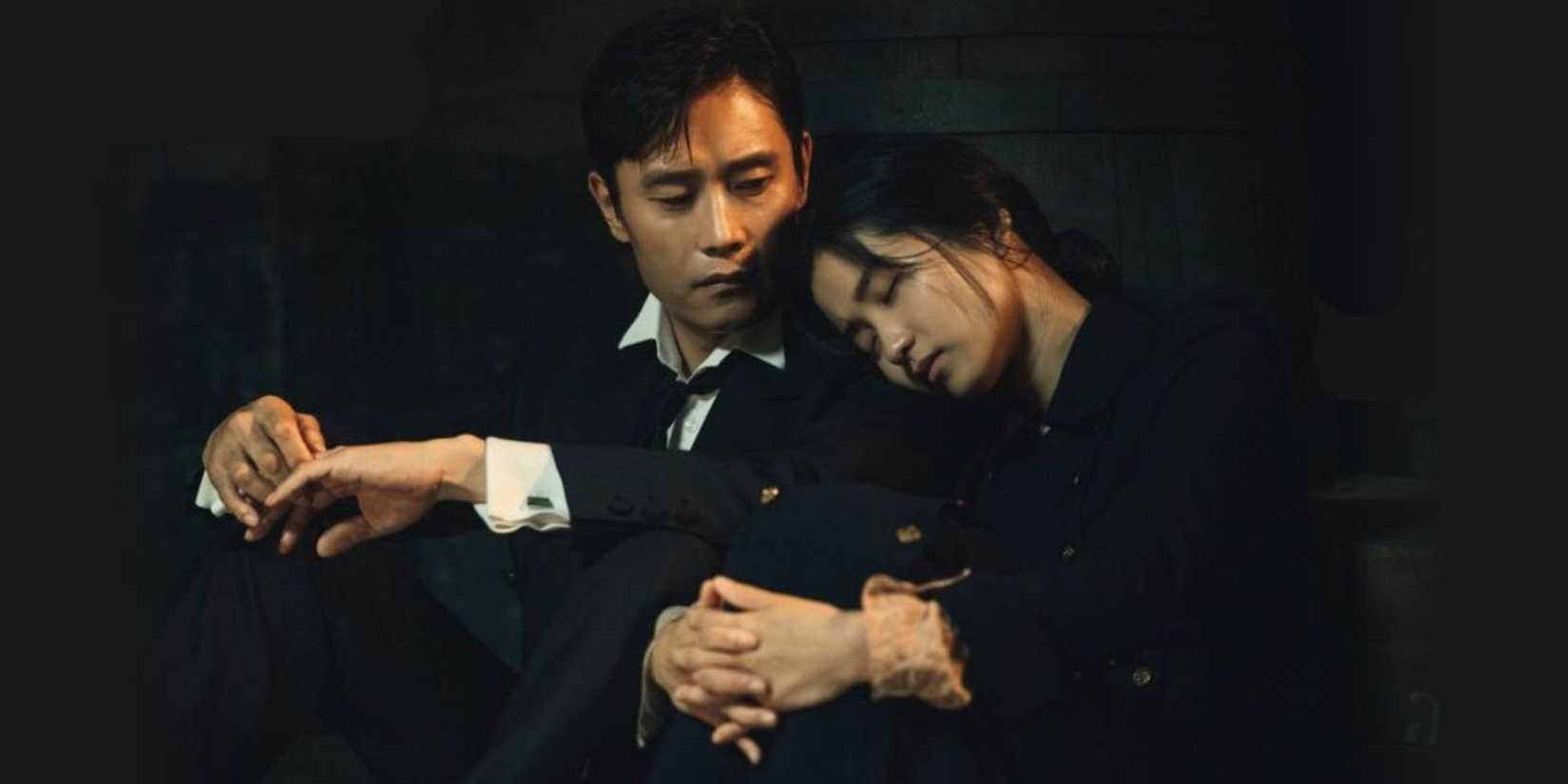 Ae-shin, played by Kim Tae-ri, leaning her head on Eugene's shoulder, played by Lee Byung-hun, as they both sit in Mr. Sunshine
