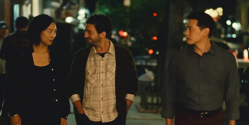 Greta Lee, Teo Yoo, and John Magaro walking together in a scene from Past Lives.