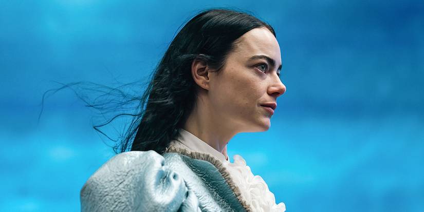 Emma Stone as Bella Baxter in front of a blue sky in Poor Things