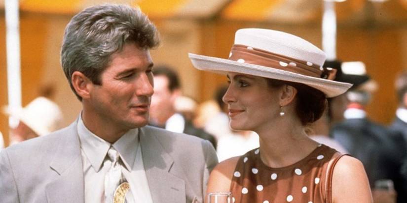 Richard Gere and Julia Roberts smiling at each other at a garden party in Pretty Woman.