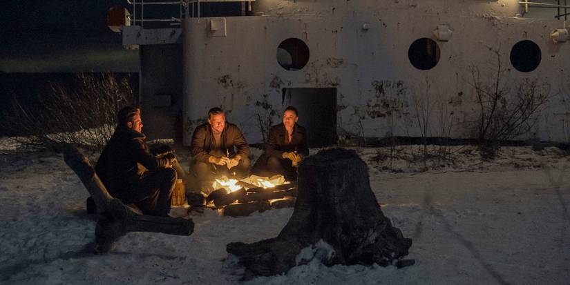O'Donnell, Reacher, and Neagley around a campfire in snow in the Reacher Season 2 finale.