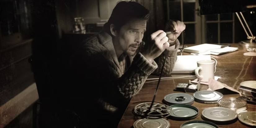 Ethan Hawke looking at a film roll in Sinister.