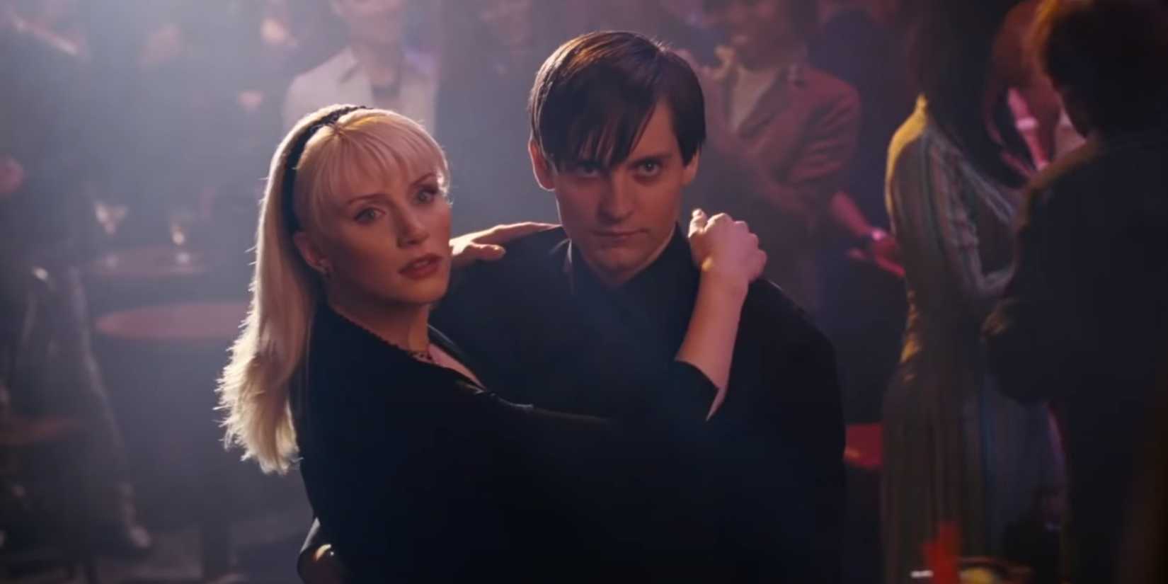 Bryce Dallas Howard as Gwen Stacy and Tobey Maguire as Spider-Man, both wearing all black, paused in their dancing and looking up with surprise to the right in Sam Raimi's Spider-Man 3