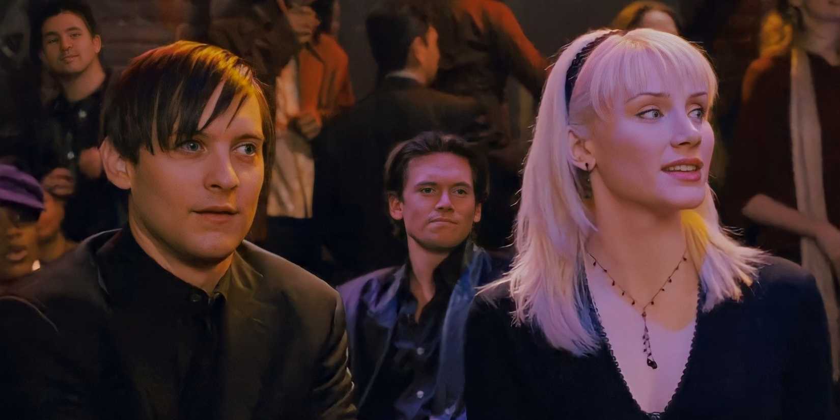 Bryce Dallas Howard as Gwen Stacy, wearing all black with her white blonde hair down, watching something and sitting next to Tobey Maguire as Spider-Man, also wearing all black, in Sam Raimi's Spider-Man 3