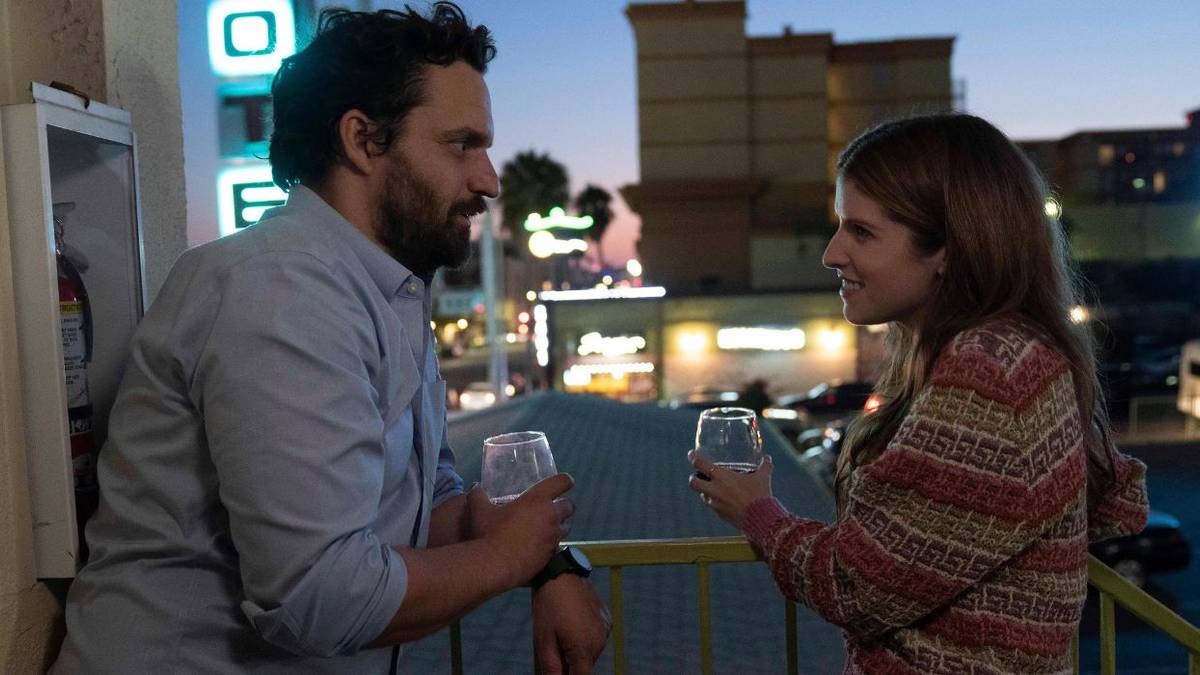 Jake Johnson and Anna Kendrick as Tommy and Maddy, drinking wine on a balcony in Self Reliance