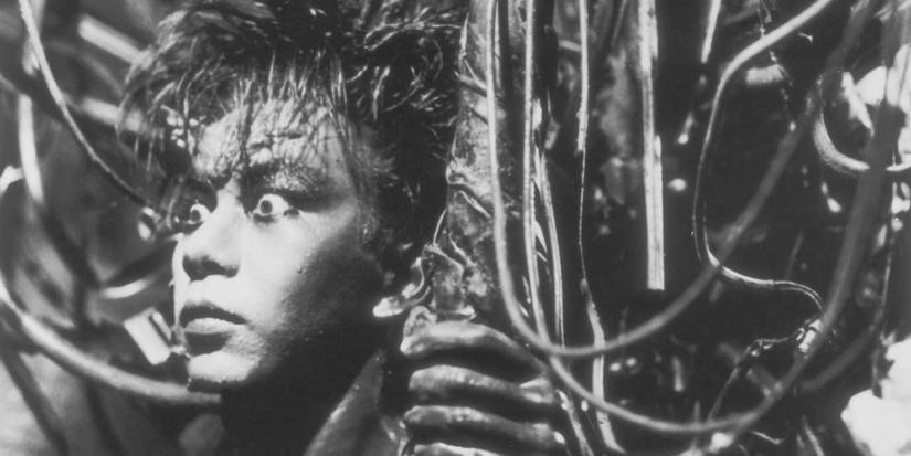 The Salaryman with eyes wide open looking ahead in 'Tetsuo: The Iron Man'