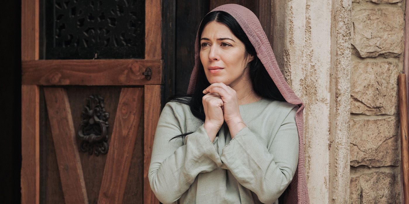 Mary Magdalene holds her hands up to her chin outside a home on 'The Chosen'