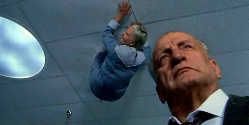 A demon crawls on the ceiling above Lt. Kinderman (George C. Scott) in Exorcist III.