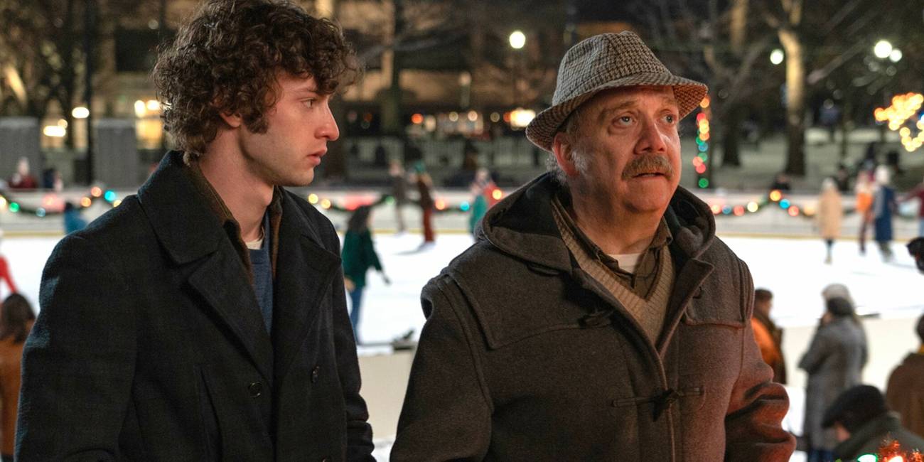 Angus (Dominic Sessa) and Hunham (Paul Giamatti) at an ice rink looking confused in The Holdovers.