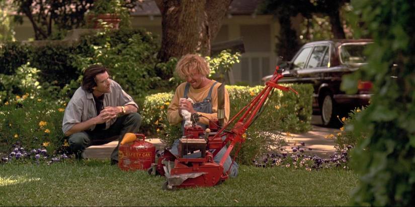 Angelo (Pierce Brosnan) and Jobe (Jeff Fahey) sitting on the lawn with Jobe's lawnmower in The Lawnmower Man