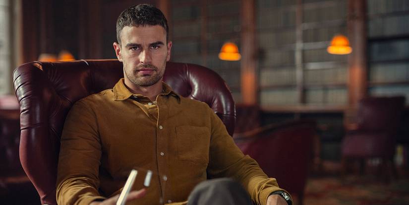 Theo James as Eddie Horniman in a leather seat in a wood-paneled library in The Gentlemen TV Series