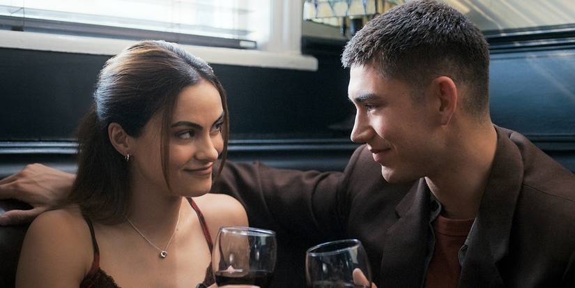 Camila Mendes and Archie Renaux, holding drinks and looking at each other in Upgraded