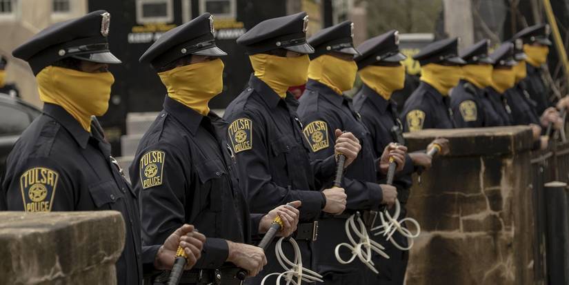 Cops with yellow masks up to their noses, forming a line, brandishing clubs in Watchmen.