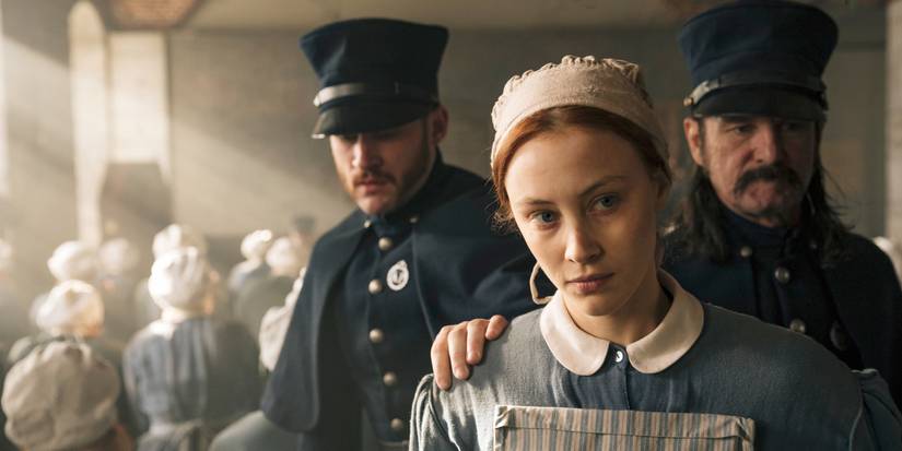 Grace Marks, played by Sarah Gadon, looking slightly to the left with a neutral expression and as two guards behind her push her ahead, in Alias Grace