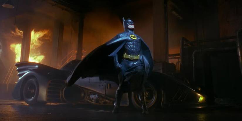 Batman next to the Batmobile looking up in Batman