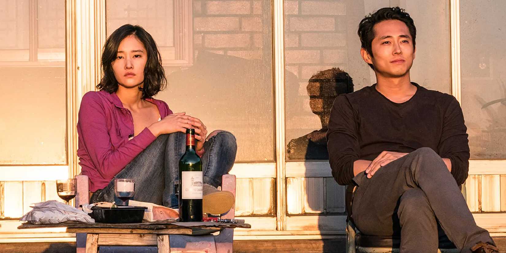 Hae-mi and Ben sitting on a porch looking ahead in Burning