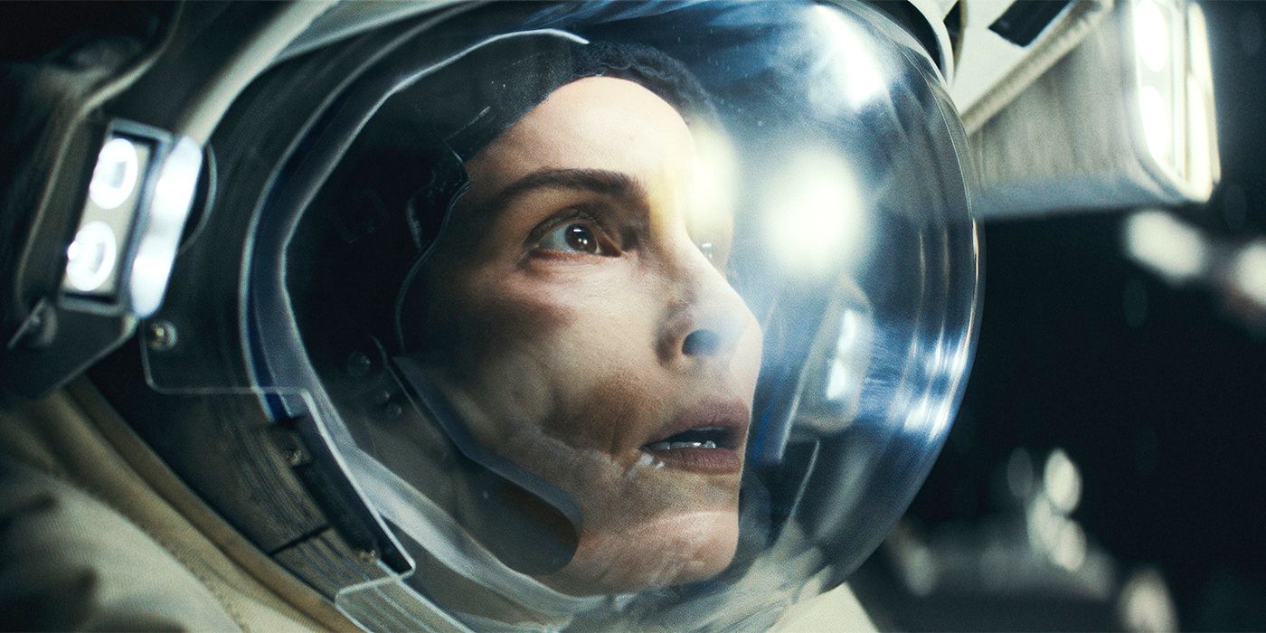 Noomi Rapace as Jo Ericsson doing a walk on the I.S.S. in a space suit and looking concerned as her face is illuminated by the bright lights in Apple TV+'s Constellation