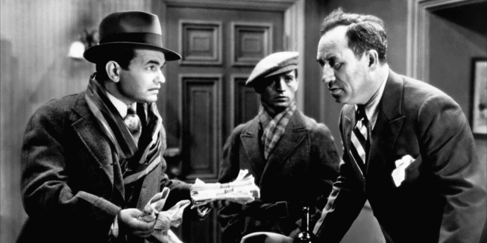 Edward G. Robinson looking at a man leaning over a desk in Little Caesar (1931)