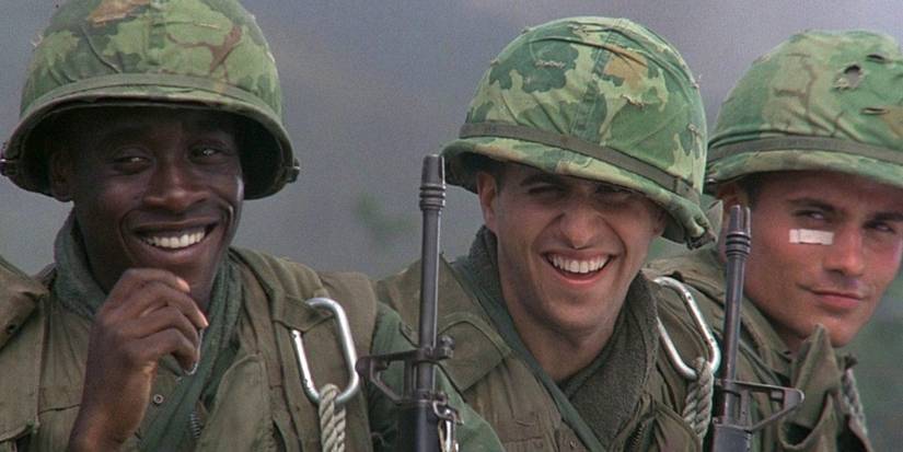 Don Cheadle and co-stars as soldiers smiling at a person offscreen in Hamburger Hill