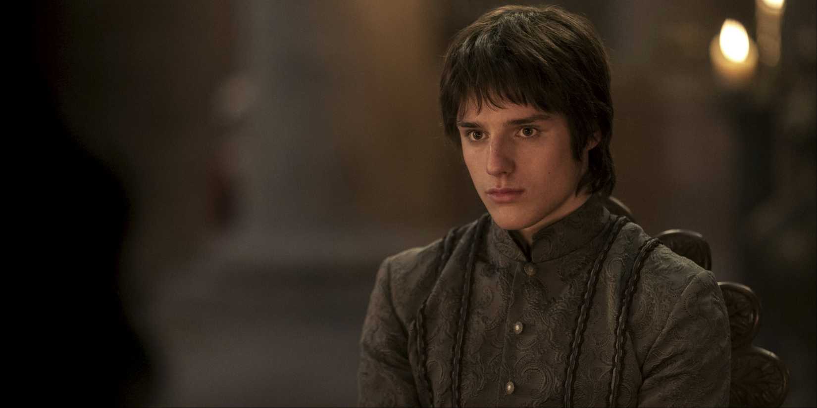 Jacaerys Velaryon sitting on a table and looking intently ahead in House of the Dragon