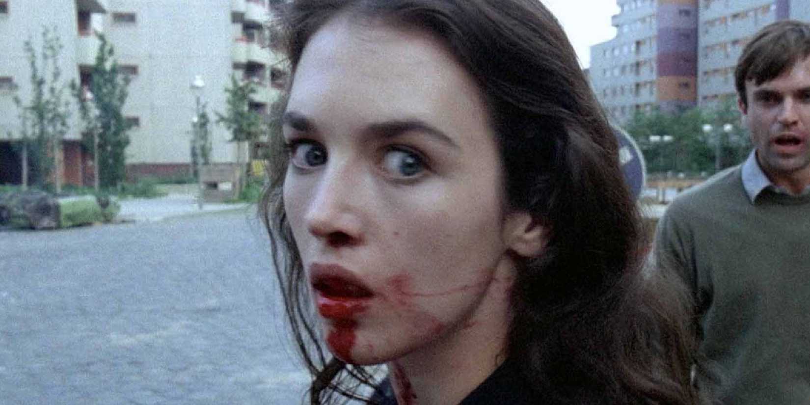Anna with a bloody mouth, while Sam Neill as Mark stands behind, in 1981's Possession 