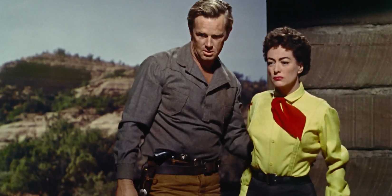 Johnny Logan (Sterling Hayden) standing behind Vienna (Joan Crawford) in 'Johnny Guitar'