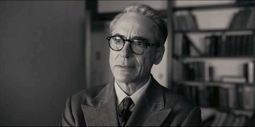 Lewis Strauss (Robert Downey Jr.) stands in his office, disgruntled, as he talks with Oppenheimer.