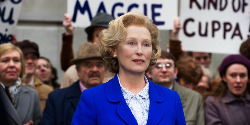 Margaret Thatcher, berdiri di tengah kerumunan orang yang memegang tanda di The Iron Lady