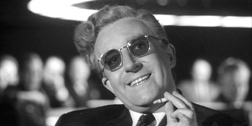 Dr. Strangelove smoking a cigarette and smiling in Stanley Kubrick's Dr. Strangelove. 