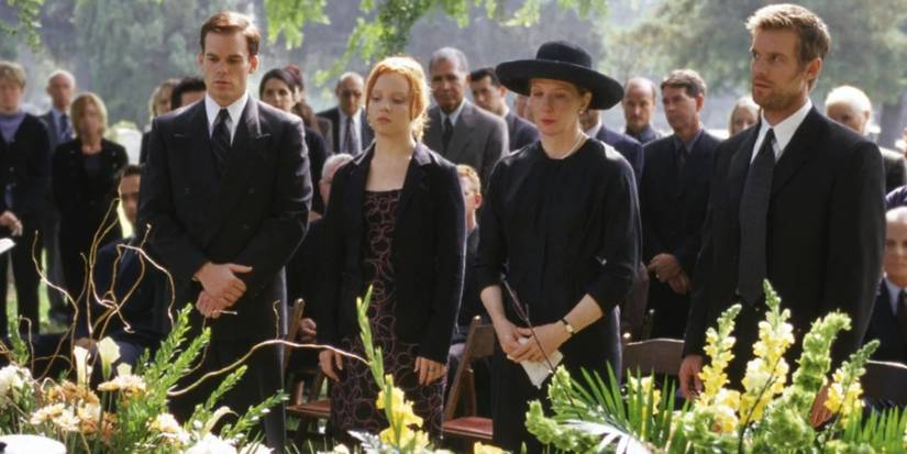 Image from Six Feet Under's pilot released in 2001 of people standing at a graveside service.