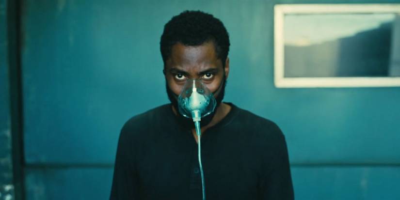 John David Washington wearing an oxygen mask and staring down the camera in Tenet