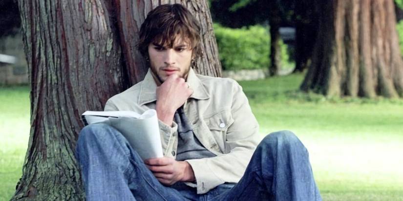 Ashton Kutcher sitting against a tree trunk, reading a book in The Butterfly Effect