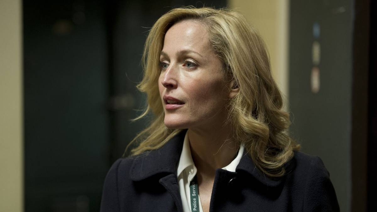 Gillian Anderson as Stella Gibson in an office hallway looking to the left in The Fall.