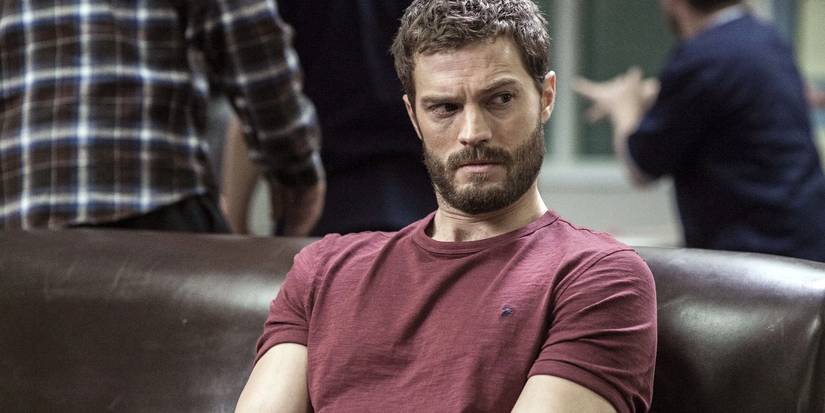Jamie Dornan as Paul Spector sitting on a leather couch and looking to the right in The Fall.