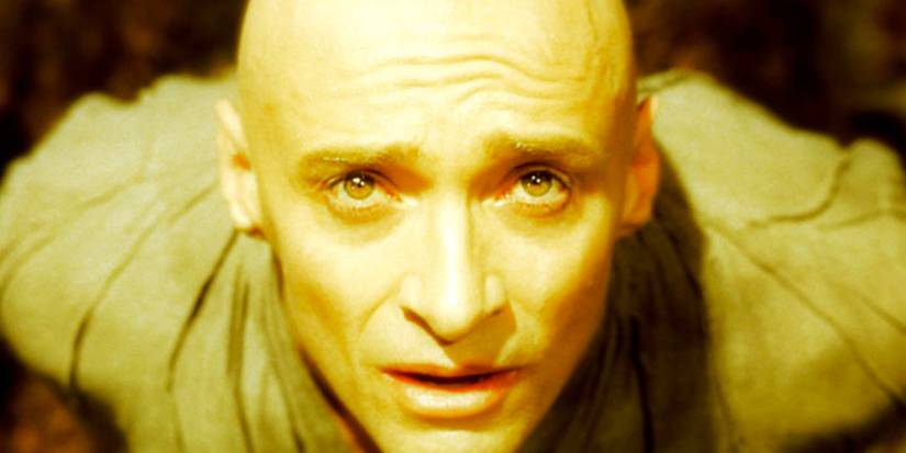 A man looks up into a golden light with a look of awe on his face in The Mountain.